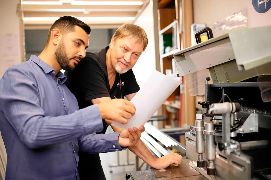Mitarbeiter in der Produktion im Sägeraum, beim präzisen Zuschnitt von Materialien für Lichtsysteme.