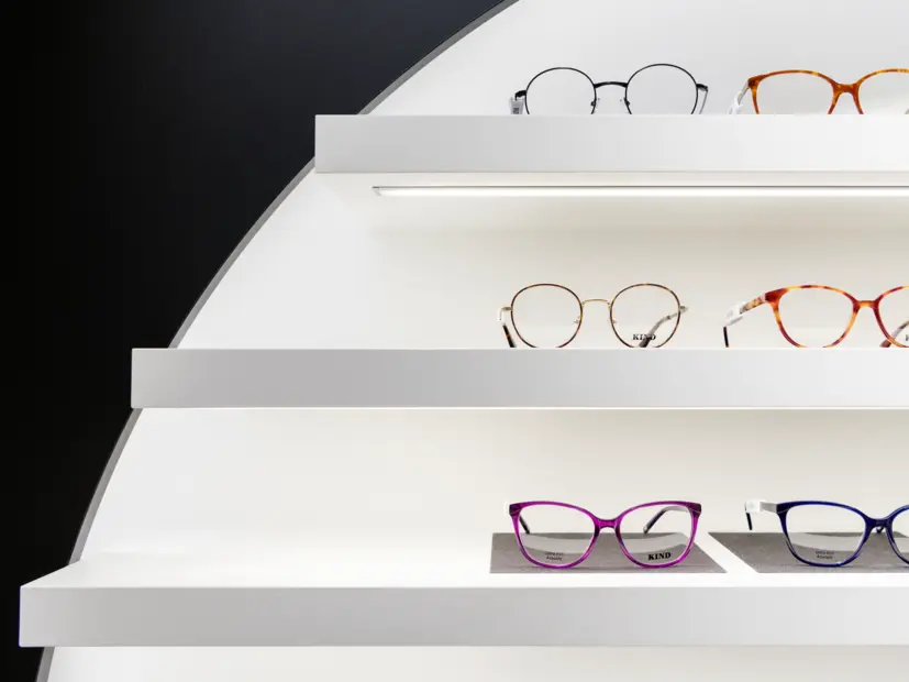Nahaufnahme eines beleuchteten Brillenregals in der Filiale Götting – moderne LED-Beleuchtung für optische Warenpräsentation