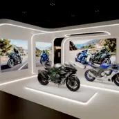 Messestand mit Motorrädern und integrierten LED-Lichtsystemen zur Produktpräsentation.